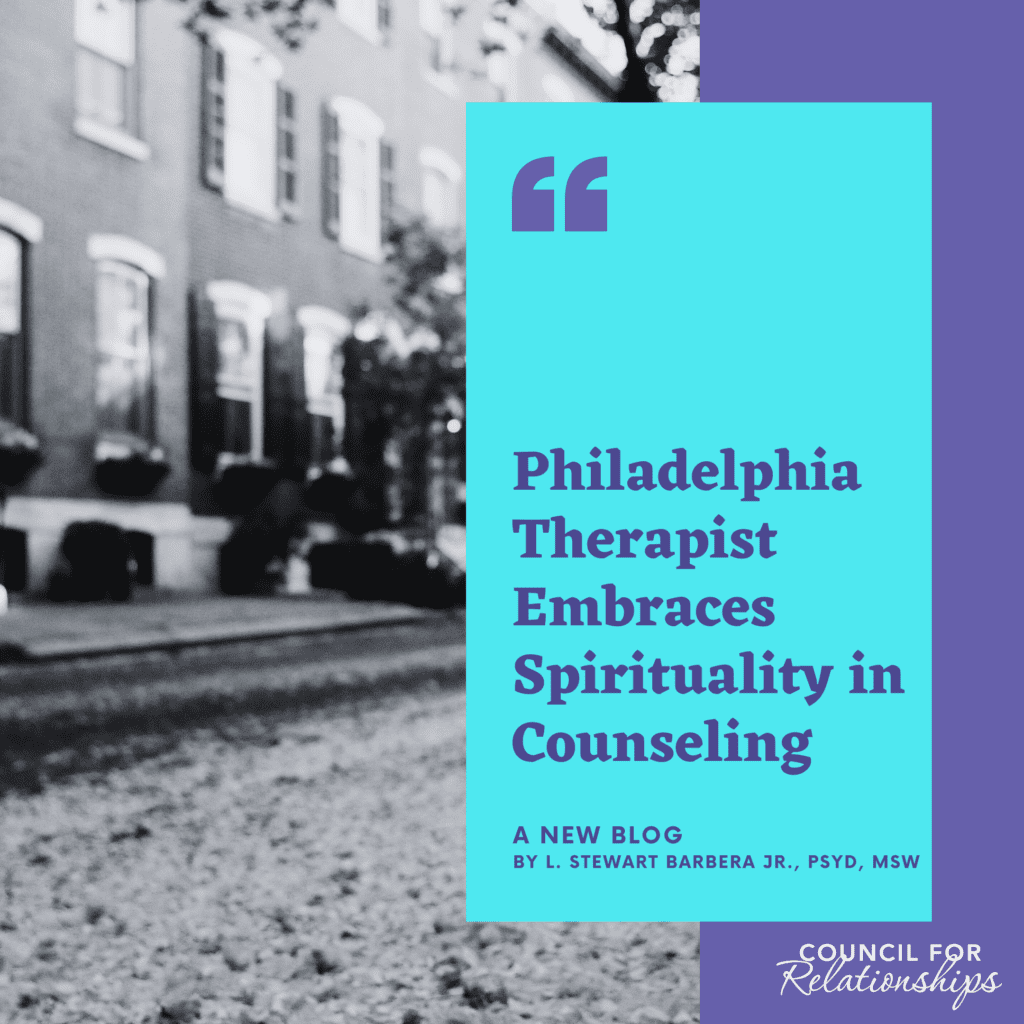 The image is a promotional graphic for a blog post, with a background photograph of a row of traditional brick townhouses that could be found in Philadelphia. In the foreground, there is a translucent overlay with text that reads "Philadelphia Therapist Embraces Spirituality in Counseling" in bold white letters. Below the headline, it states "A NEW BLOG" followed by the author's name "By L. Stewart Barbera Jr., PsyD, MSW" in smaller font. The text is arranged on a bright cyan-colored rectangle which contrasts with the background. The graphic is designed to be eye-catching and informative, likely intended for sharing on social media or a website to attract readers to the blog article.