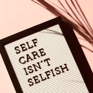 Sign stating self care isn't selfish as tip for mental health management